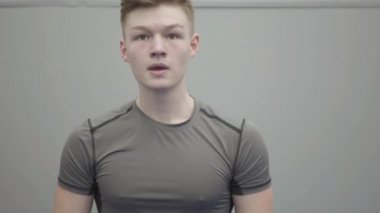 Kendine güveni tam genç bir adamın portresi. Havayı yumrukluyor, tekmeliyor. Spor salonundaki yeteneklerini yakından gösteriyor. Genç bir kadın arka planda kuklayı tekmeliyor. Dövüş sanatları kavramı