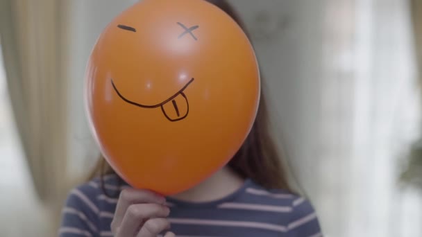 Ένα Αστείο Χαριτωμένο Κορίτσι Κρατήσει Πορτοκαλί Baloon Emoji Και Κάνει — Αρχείο Βίντεο