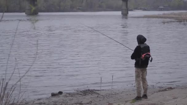 Впевнений Молодий Рибалка Штанях Хакі Вранці Обертається Риболовля Річці Поблизу — стокове відео