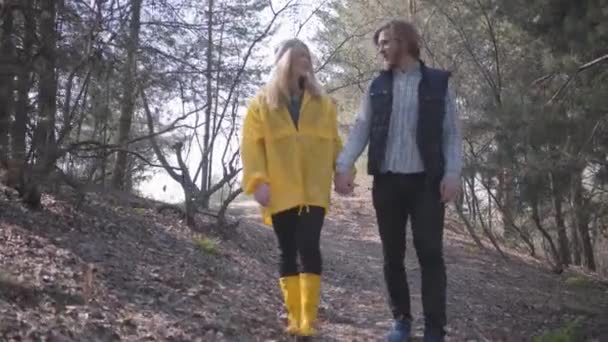 男男女女手牵手在春天的森林里散步 戴着帽子 黄靴和外套 视频的女人 — 图库视频影像