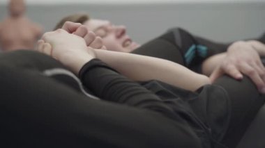 Atletik bir adam ve tanınmayan bir kadın yerde güreş tutuyorlar. Erkek ve dişi dövüşçüler birbirini yakalar. Adam sıkıca kavrıyor ve elleriyle yere vuruyor, pes ediyor. Dövüş sanatları kavramı