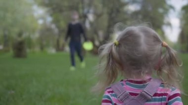 Ağabey ve küçük kız kardeş güzel yeşil parkta koşuyorlar. Küçük kız düşer ve oğlan ayağa kalkmasına yardım eder. Mutlu carring ailesi.