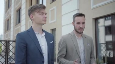 Resmi olarak kendine güvenen iki adamın portresi terasta yürürken yeni proje, iş konsepti, video tartışmaları... 