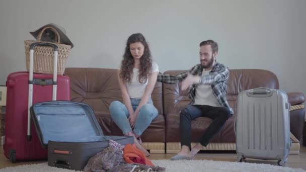 Sakallı Genç Adam Kollarını Sallayan Kıza Bağırıyor Odada Bavullarını Toplayan — Stok video