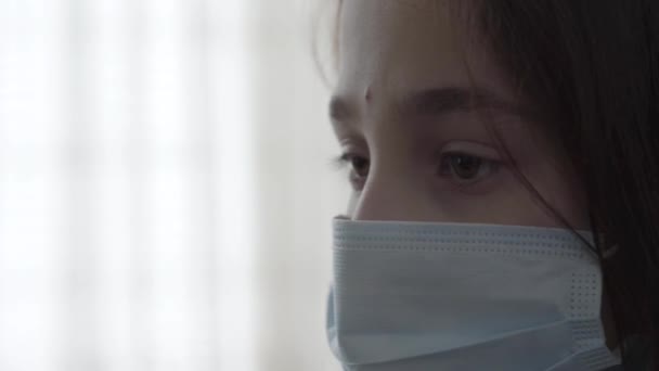 Menina Doente Triste Com Máscara Estéril Rosto Olhando Para Baixo — Vídeo de Stock