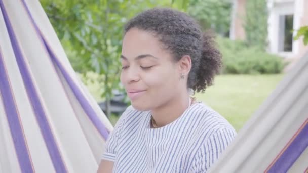 Primer Plano Retrato Una Joven Afroamericana Sonriente Sentada Hamaca Relajándose — Vídeo de stock