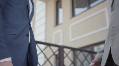 İki erkek ortak terasta el sıkışıyor. Meslektaşlar iyi bir anlaşma yaptı, video. 