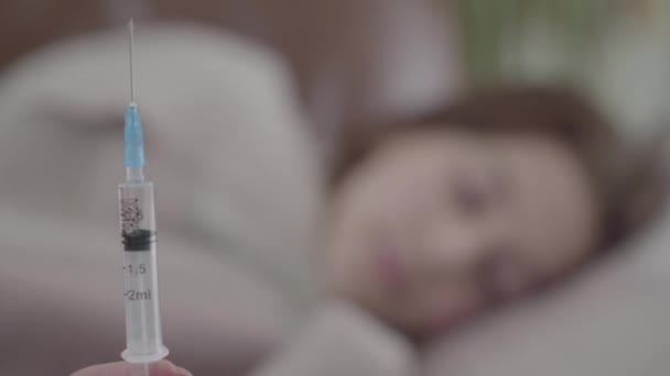 ベッドと注射器の中の女性のシルエットを閉じる — ストック動画