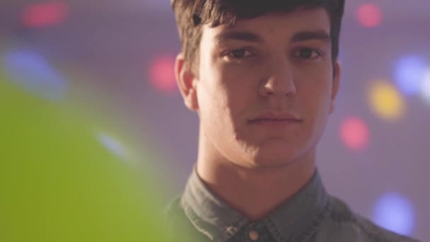 Retrato Joven Sonriente Con Sombrero Cumpleaños Mirando Cámara Luces Brillantes — Vídeo de stock