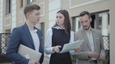 Resmi olarak genç kadınlar ve erkekler terasta yürürken projeyi, videoyu tartışıyorlar.