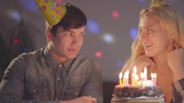 Chica Rubia Con Sombrero Cumpleaños Soplando Velas Pastel Joven Sentado — Vídeo de stock