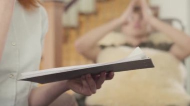 Bir psikoterapistle resepsiyondaki genç adam. Tanınmayan bir psikoloğun kadın eli bir not defterine ya da hasta kartına bir şeyler yazıyor.