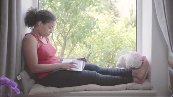 Vídeo Mulher Afro Americana Sentada Peitoril Janela Digitando Laptop Menina — Vídeo de Stock