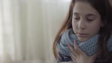Sıcak bir eşarba sarılı genç bir kızın portresi elinde bir fincan sıcak çay tutuyordu. Kız kendini kötü hissediyor, hasta ve ateşi var. Sağlık ve tedavi kavramı