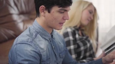 Evde zor kitabı okuyan genç bir çift. Esmer bir adam ve sarışın bir kadının portresi kumaşı tartışıyor, çalışıyor. Evde öğreniyorum.