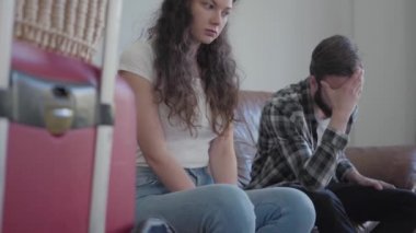 Genç çift, evdeki deri koltukta oturmadan önce gergin, video.