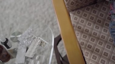 Haplar, ilaç, masada şurup ve bej köpek oyuncağıyla sallanan çocuk..