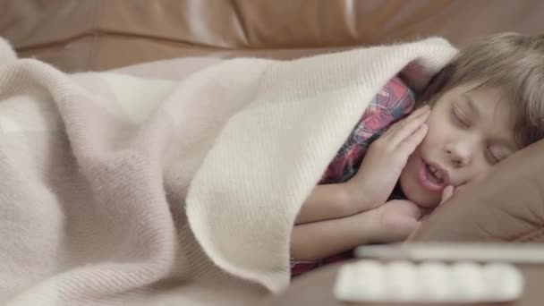 Видео Больного Мальчика Чихающего Лежащего Диване Покрытом Одеялом Дома — стоковое видео