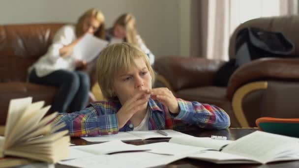 Niño Cansado Sentado Mesa Con Cuadernos Casa Madre Hermana Sentadas — Vídeos de Stock