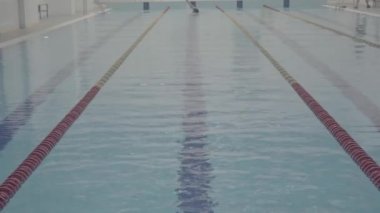 Profesyonel sporcu, kapalı alanda boş havuzda zar zor yüzüyor. Sağlıklı bir yaşam tarzı. Spor ve eğlence..