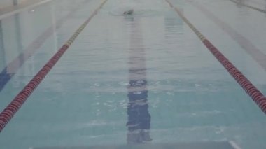 Profesyonel yüzücü, kapalı havuzda zar zor yüzüyor. Sağlıklı bir yaşam tarzı. Spor ve eğlence..