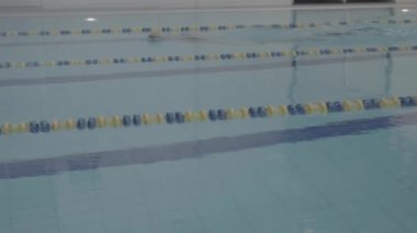 Becerikli yüzücü, kapalı havuzda zar zor yüzüyor. Sağlıklı bir yaşam tarzı. Spor ve eğlence..