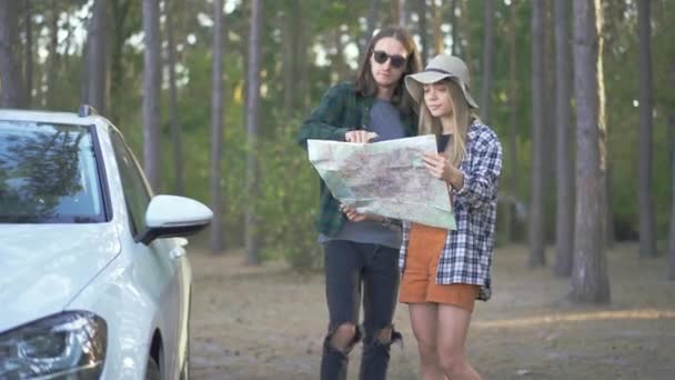 戴着帽子的可爱女孩 戴着太阳镜的年轻人呆在森林里 试着选择去看地图的路 幸福的夫妻在一起 — 图库视频影像