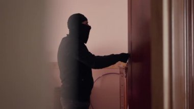 Siyah elbiseli ve kar maskeli bir hırsız büyük yatak odasındaki dolabı açıp para arıyor. Bir şeyler çalan adam. Suç kavramı, suç, kanuna karşı suç