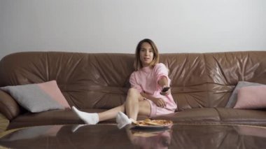 Evdeki kahverengi deri koltukta oturup televizyon izleyen sıkıcı beyaz bir kadın. Yakışıklı adam şarap şişesi ve bardak getiriyor. Evli çiftler evde romantik bir akşam yemeği yer.