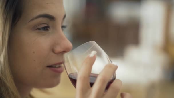 ガラス越しに赤ワインを飲む大人の白人女性のクローズアップ顔 自宅やレストランでお酒を楽しむ女性 酒を飲んでリラックス — ストック動画