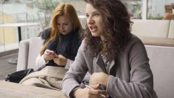 Dos Novias Caucásicas Sentadas Mesa Café Una Chica Sosteniendo Teléfono — Vídeos de Stock