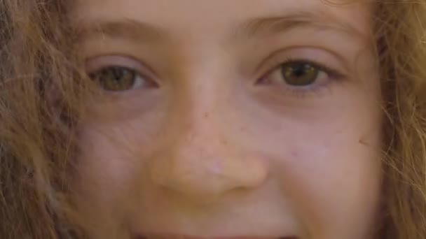 一个红头发的白人小女孩棕色眼睛的特写 头发卷曲的孩子看着相机笑着 — 图库视频影像