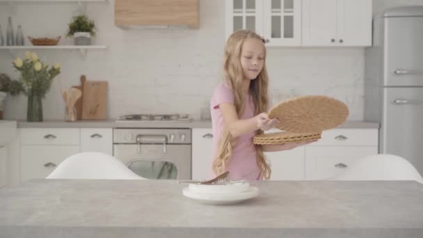 Jong Blank Meisje Roze Jurk Zet Platenonderzetters Aan Tafel Glimlacht — Stockvideo