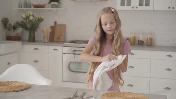 年轻的白种人少女穿着粉红的衣服在现代厨房里擦盘子 望着别处 叹了口气 勤奋的金发少女帮她的家人做家务活 — 图库视频影像