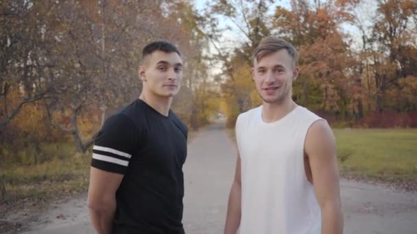 Portrait Two Positive Caucasian Bodybuilders Talking Camera Autumn Park Starting — ストック動画