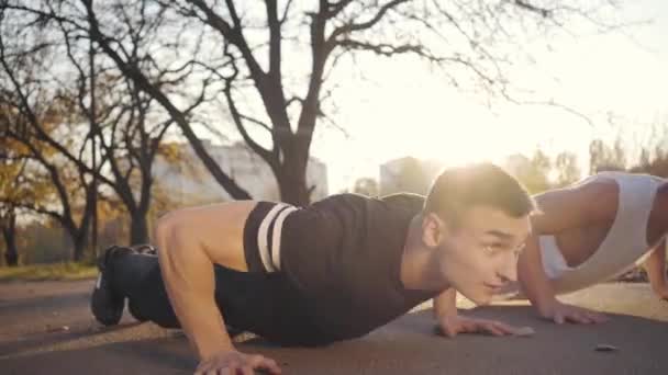 Twee Knappe Blanke Sporters Die Bij Zonsondergang Het Najaarspark Omhoog — Stockvideo