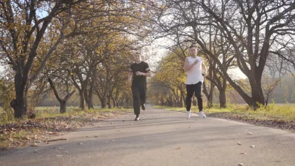 Sportieve Blanke Jongens Rennen Het Najaarspark Volwassen Sporters Stoppen Vanwege — Stockvideo
