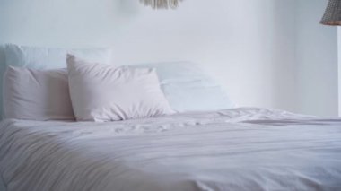 Sabahları beyaz yastıkları büyük yataklara atıyorlar. Bilinmeyen kişi yatak odasına temiz yatak koyuyor. Rahatlama, ev, ev.