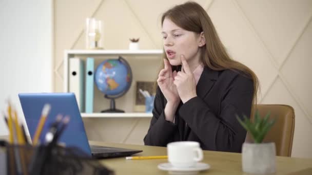 Retrato de una profesora profesional que explica la pronunciación del inglés en línea. Confiado joven pelirroja caucásica mujer enseñando el lenguaje en el chat inalámbrico. Estilo de vida, educación, lección . — Vídeo de stock