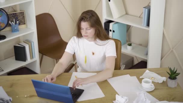 Vista superior de la joven mujer enviando proyecto en línea y recostado cabeza abajo en la mesa. Freelancer caucásico agotado durmiendo frente a la computadora. Sobretrabajo, estilo de vida, agotamiento, trabajo remoto . — Vídeo de stock