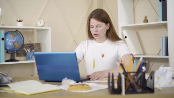 Egy fiatal nő sóhajtozik, megnyomja a gombot a laptopon, és hátradől. Portré fáradt kaukázusi vöröshajú szabadúszó küldő munka online. Szabadúszó, túlhajszolt, távoli munka, fáradtság. — Stock videók