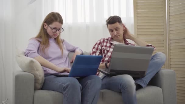 Zenuwachtige roodharige vrouw schreeuwt tegen brunette jongeman die haar zijn laptop scherm laat zien. Portret van een ontevreden blanke vriendin die ruzie had met haar vriendje thuis als surfen op internet. Lifestyle, conflict — Stockvideo