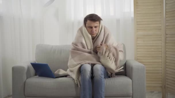 Jonge vrouw brengt beker met warme drank naar zieke blanke man gewikkeld in deken. Vriendin of vrouw die zorgt voor vriend of echtgenoot die lijdt aan respiratoire virale infectie. Gezondheidszorg. — Stockvideo