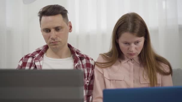 Gros plan d'un homme et d'une femme en colère fatigués croisant les mains et regardant la caméra avec une expression faciale insatisfaite. Portrait de pigistes épuisés travaillant à domicile. Mode de vie, télétravail, surmenage — Video