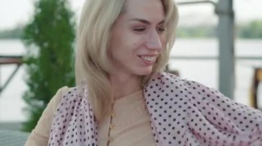 Açık yaz eşarbı takan kahverengi gözlü çekici sarışın kadının yakın çekimi. Açık havada aksesuar deneyen mutlu beyaz kadın portresi. Yaşam tarzı, güzellik, moda, neşe.