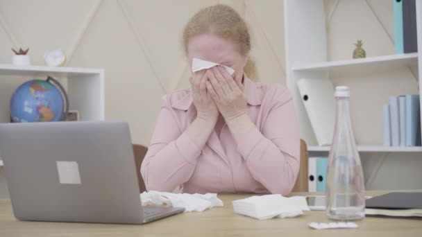 Depressieve senior vrouw huilt in het kantoor. Portret van wanhopige roodharige blanke vrouw met stress op het werk. Emotionele stabiliteit, stress, overwerk, pensionering. — Stockvideo