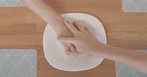 Widok nierozpoznawalnych braci walczących o ostatnie ciasteczko. Zbliżenie dzieci ręce nad białą płytą z herbatnikami na stole w kuchni. — Wideo stockowe