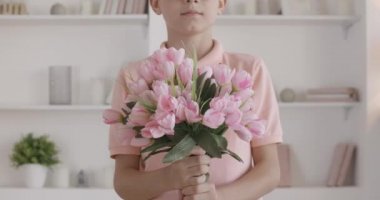 Tanımlanamayan bir çocuk kameraya pembe lale buketi uzatıyor. Nazik Kafkasyalı çocuk tatile ya da doğum gününe çiçeklerle geliyor. Küçük beyefendi hediye veriyor ve gülümsüyor..