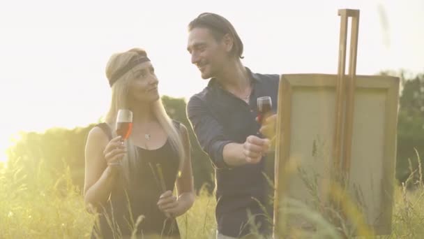 Linda mulher loira e belo homem confiante de pé com vinhedos ao pôr-do-sol ao ar livre e desenho. Sorrindo feliz caucasiano namorada admirando namorado pintura paisagem . — Vídeo de Stock