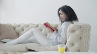 Özümsenmiş Afro-Amerikalı bir kadının evde kitap okuması. İçeride edebiyattan hoşlanan pozitif konsantre kadın okuyucunun portresi. Yaşam tarzı ve hobi kavramı.